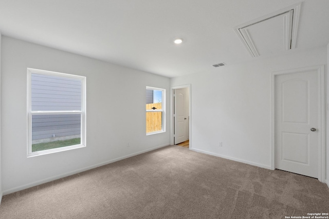 unfurnished room featuring a wealth of natural light and light colored carpet