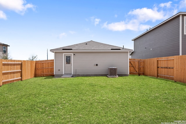 back of property featuring central AC unit and a lawn