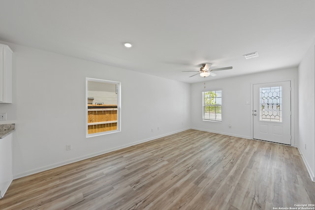 unfurnished living room featuring ceiling fan and light hardwood / wood-style flooring