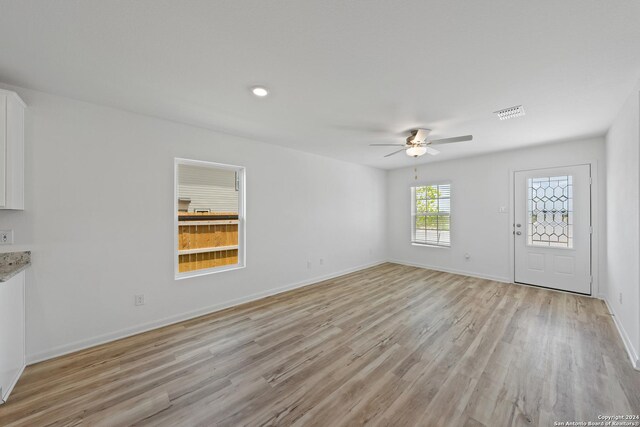 unfurnished living room featuring ceiling fan and light wood-type flooring