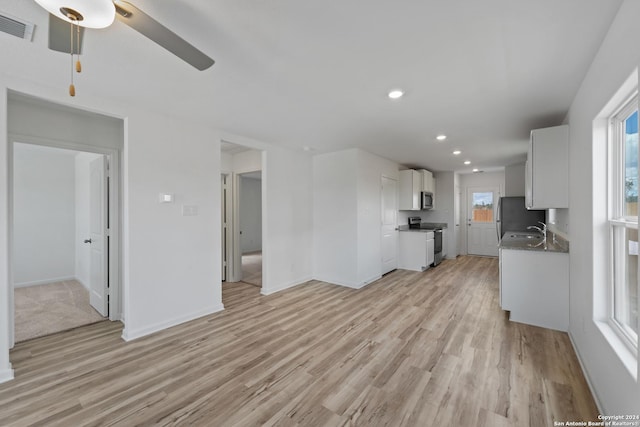 unfurnished living room with ceiling fan, sink, and light hardwood / wood-style floors