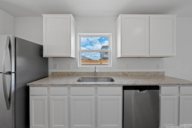 kitchen featuring stainless steel appliances, white cabinetry, and sink