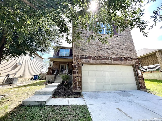 view of front of home featuring central AC unit, covered porch, and a garage