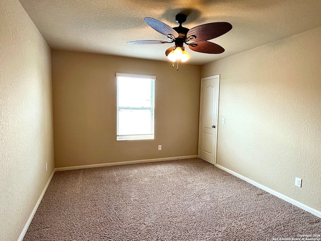 carpeted spare room featuring a textured ceiling and ceiling fan