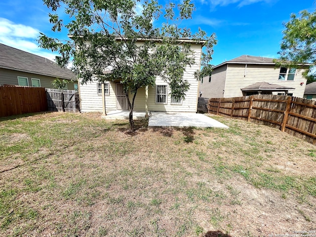 back of house featuring a lawn and a patio area