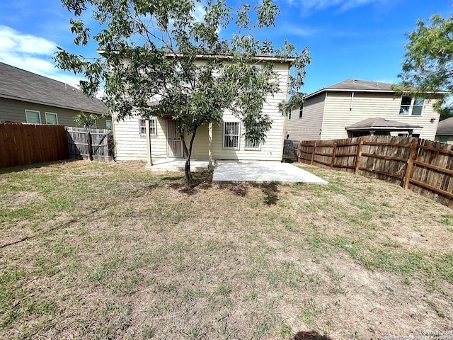 rear view of property featuring a lawn and a patio