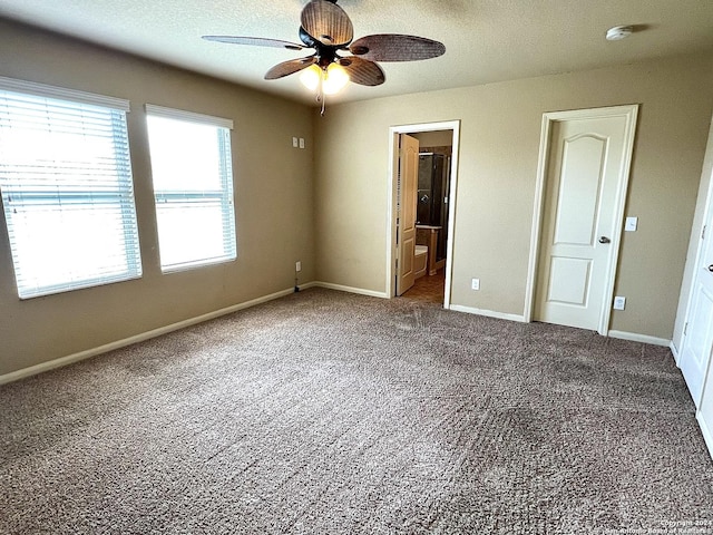 unfurnished bedroom with ceiling fan, connected bathroom, and carpet