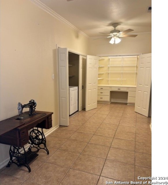 interior space with washer / clothes dryer, light tile patterned flooring, crown molding, and ceiling fan