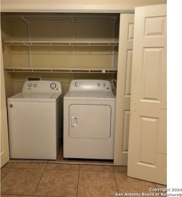 washroom with washing machine and clothes dryer and light tile patterned floors