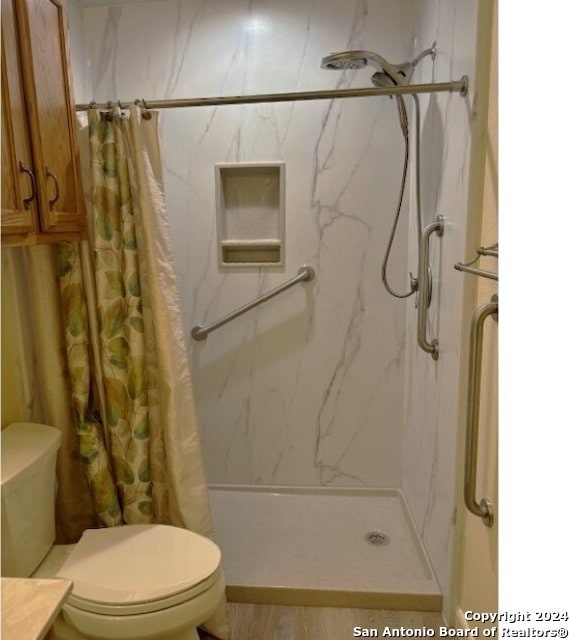 bathroom featuring toilet and a shower with curtain