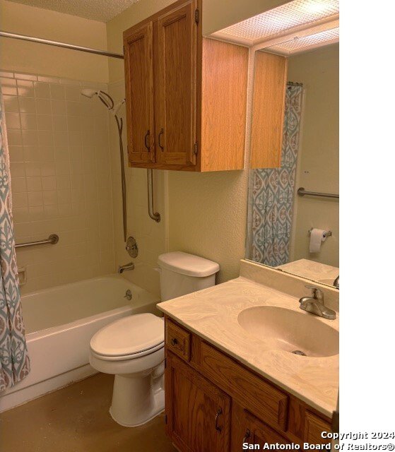 full bathroom featuring vanity, a textured ceiling, toilet, and shower / bath combination with curtain