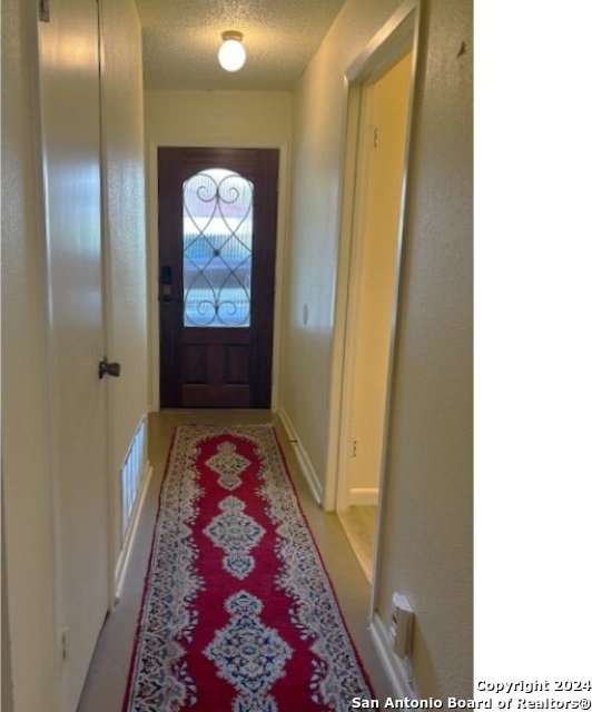 doorway with a textured ceiling