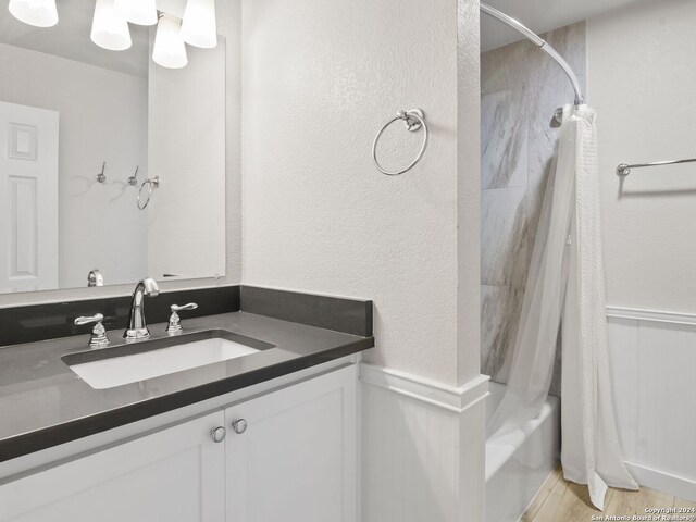 bathroom with vanity, hardwood / wood-style floors, and shower / tub combo