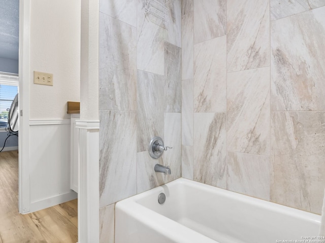 bathroom featuring tiled shower / bath combo and hardwood / wood-style flooring