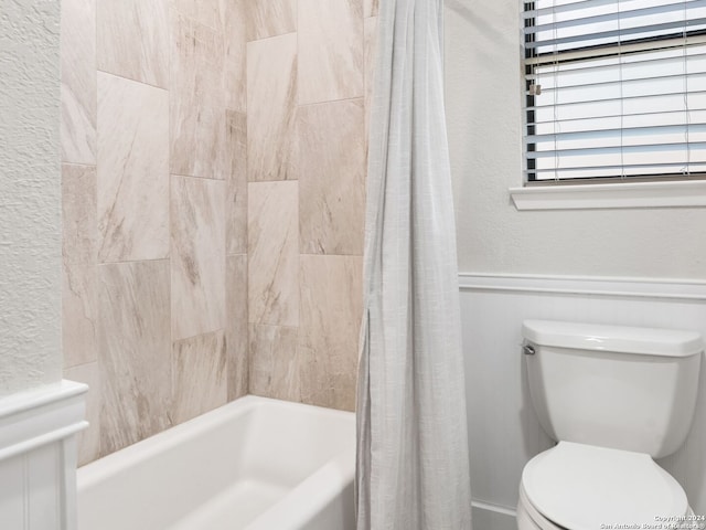 bathroom with shower / tub combo with curtain and toilet