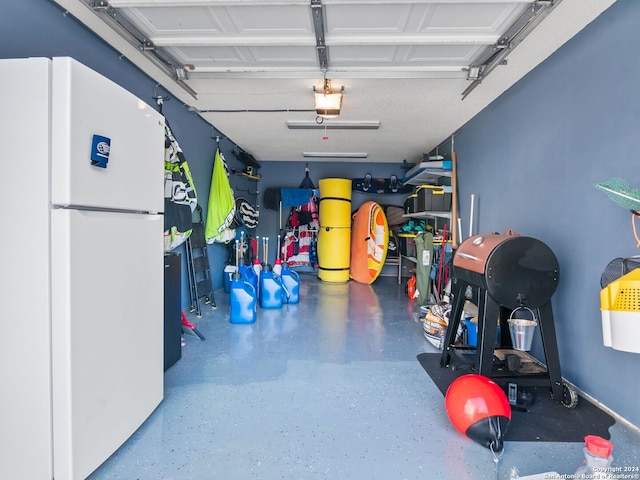 garage with a garage door opener and white fridge