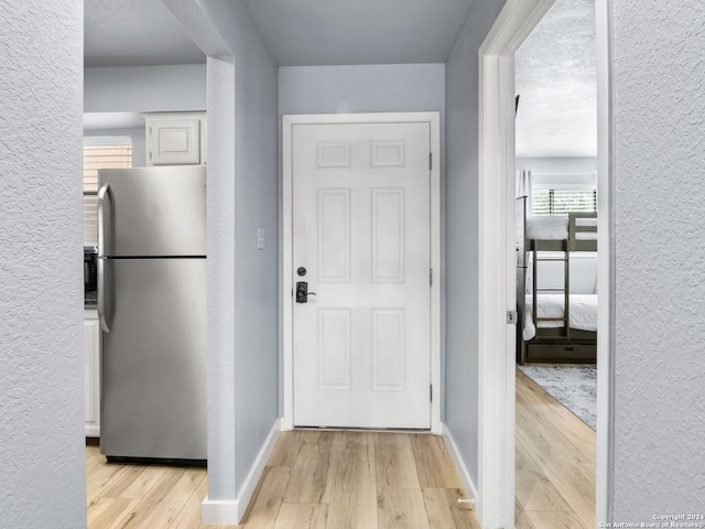 interior space with a textured ceiling and light wood-type flooring