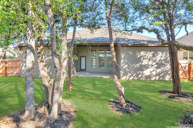 back of house featuring a patio area and a lawn