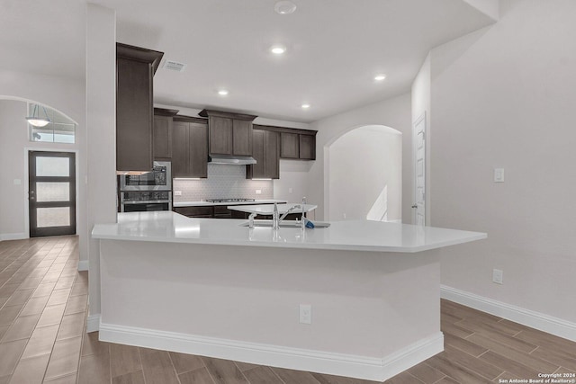 kitchen with sink, stainless steel appliances, dark brown cabinets, and tasteful backsplash