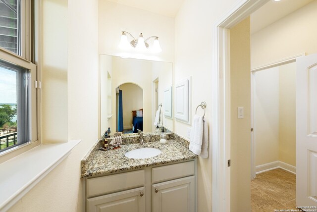 bedroom featuring ceiling fan and ensuite bath