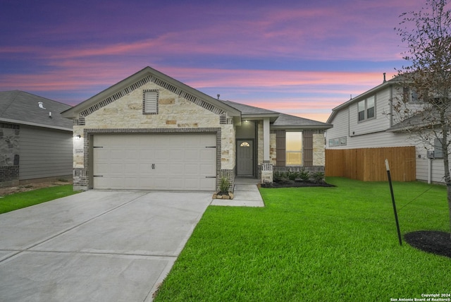 view of front of property with a garage and a lawn