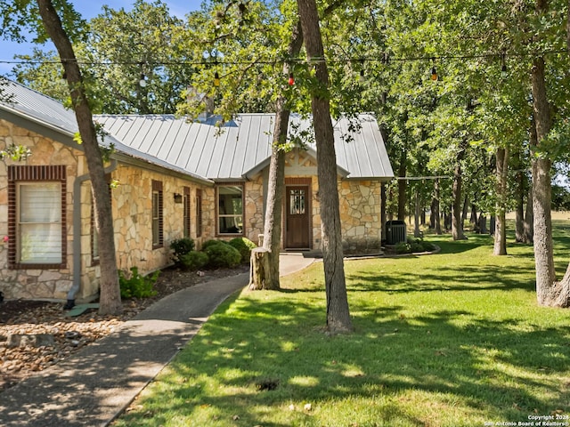 view of front of home featuring central air condition unit and a front lawn