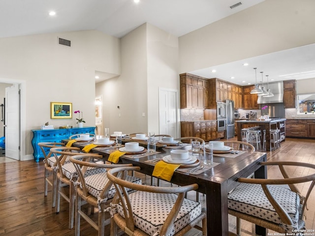 dining space featuring high vaulted ceiling and wood-type flooring