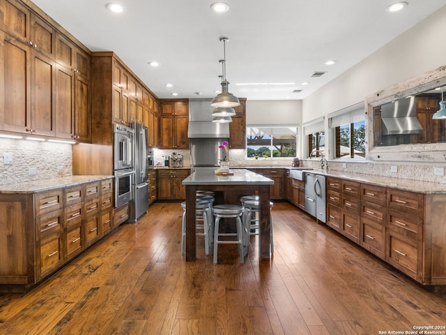 kitchen with backsplash, dark hardwood / wood-style flooring, and wall chimney range hood