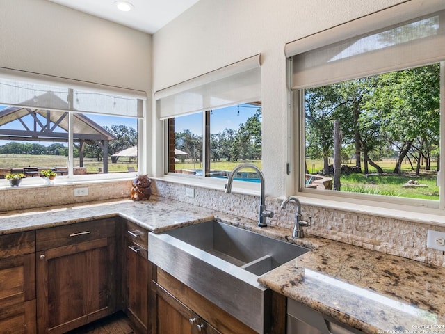 5 Old Fredericksburg, Boerne, TX 78015 - kitchen featuring a sink, decorative backsplash, dark brown cabinets, and light stone countertops