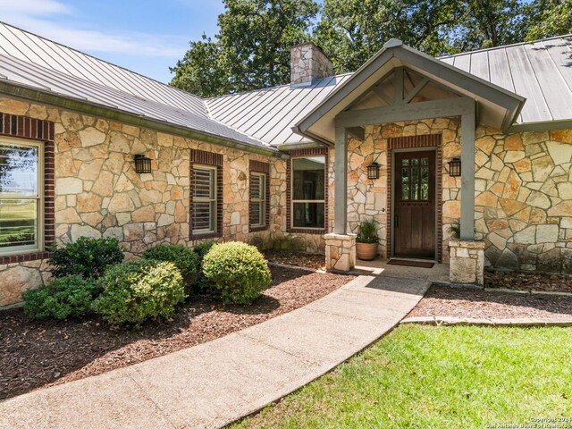 5 Old Fredericksburg, Boerne, TX 78015 - doorway to property with a standing seam roof, metal roof, stone siding, and a chimney