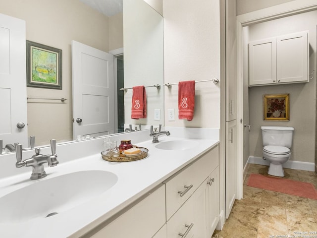 bathroom featuring tile patterned floors, toilet, and dual bowl vanity