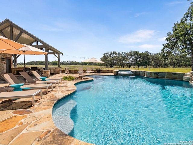 view of pool with an in ground hot tub and a patio