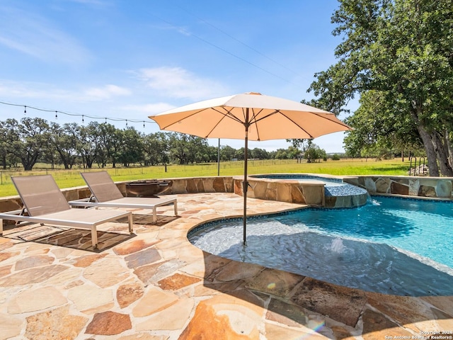 view of swimming pool with pool water feature and a patio area