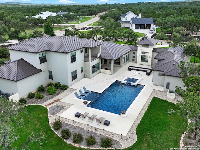 view of swimming pool featuring area for grilling, a lawn, a pool with connected hot tub, and a patio