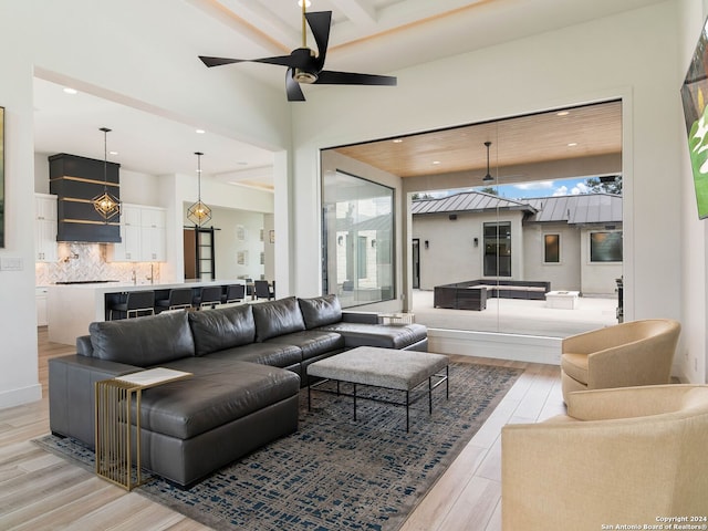 living room with ceiling fan and light hardwood / wood-style flooring