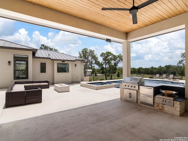 view of patio with an in ground hot tub, an outdoor living space with a fire pit, an outdoor kitchen, ceiling fan, and area for grilling