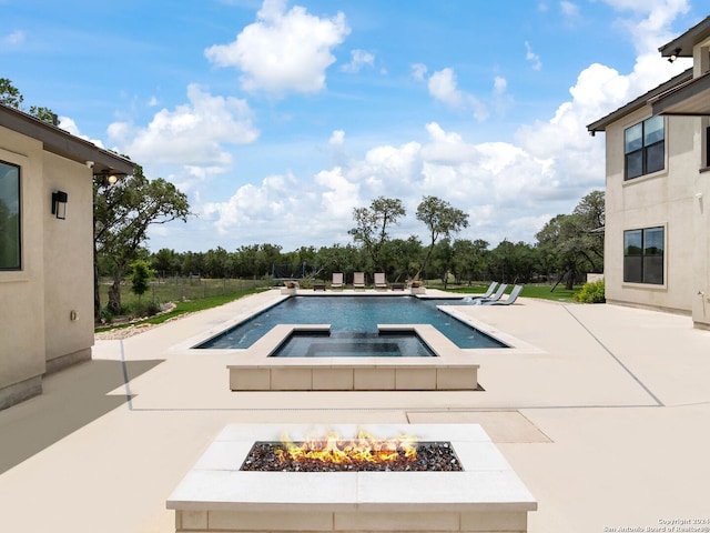 view of swimming pool with an in ground hot tub, a patio, and a fire pit