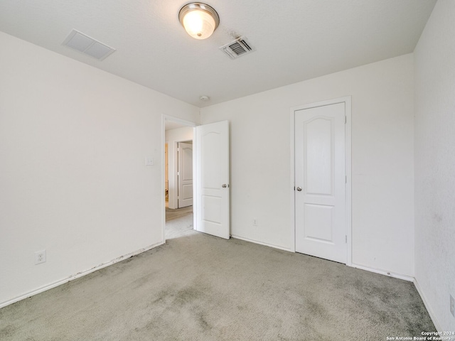 unfurnished bedroom featuring light carpet