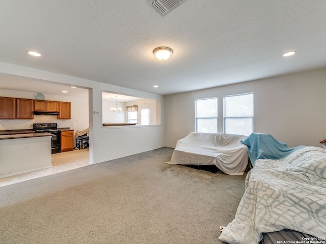 bedroom featuring an inviting chandelier, light colored carpet, and a textured ceiling