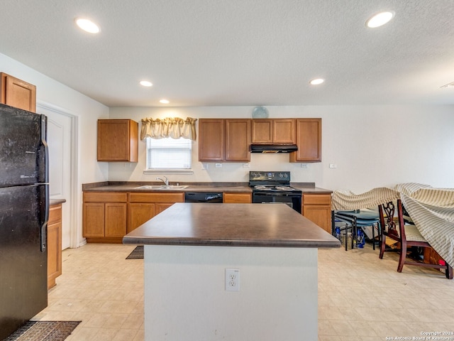 kitchen featuring a center island, sink, a textured ceiling, and black appliances