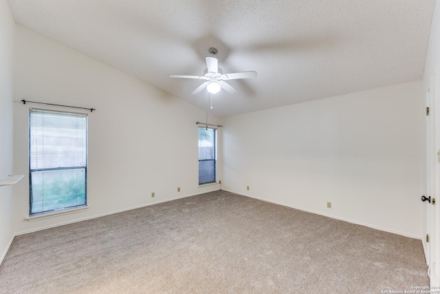 unfurnished room featuring lofted ceiling, a textured ceiling, ceiling fan, and carpet