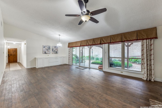 unfurnished living room with lofted ceiling, dark wood-type flooring, a textured ceiling, and ceiling fan with notable chandelier