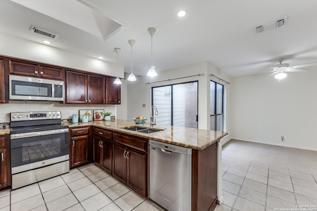 kitchen with appliances with stainless steel finishes, kitchen peninsula, sink, and light tile patterned floors