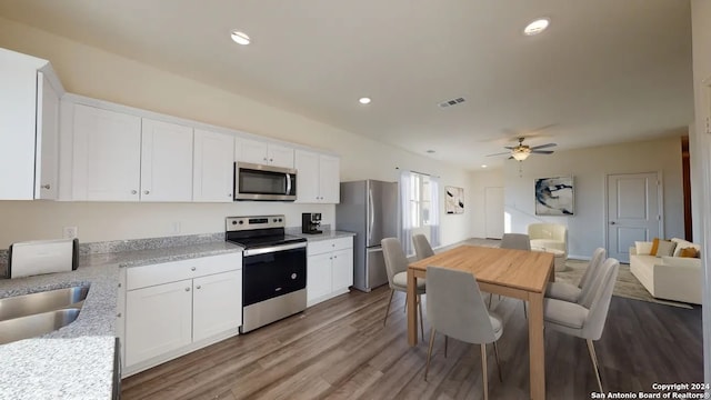 kitchen featuring stainless steel appliances, white cabinets, sink, light wood-type flooring, and ceiling fan