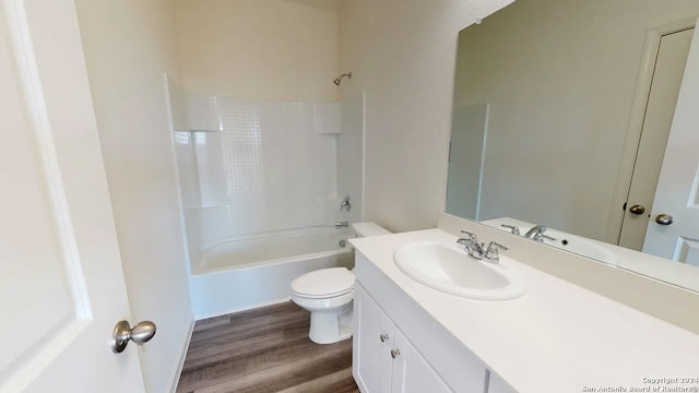 full bathroom with hardwood / wood-style flooring,  shower combination, toilet, and vanity