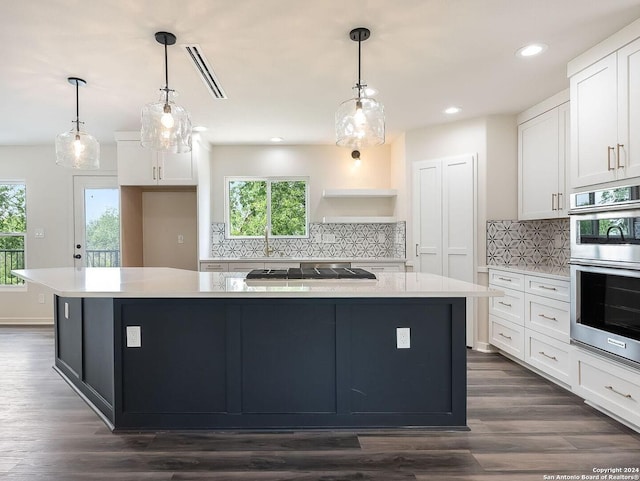 kitchen with a kitchen island, white cabinets, decorative backsplash, and stainless steel appliances