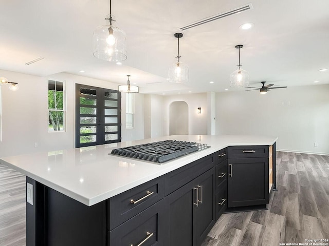 kitchen featuring pendant lighting, a spacious island, hardwood / wood-style floors, and stainless steel gas cooktop