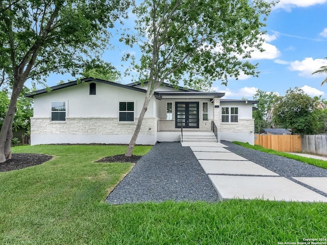 view of front facade featuring a front yard and french doors