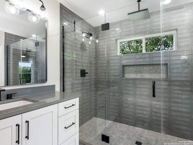 bathroom with a shower with shower door and vanity