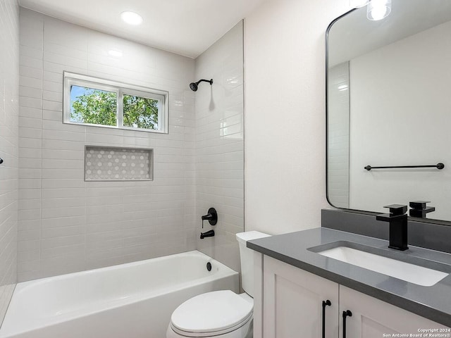 full bathroom featuring toilet, vanity, and tiled shower / bath